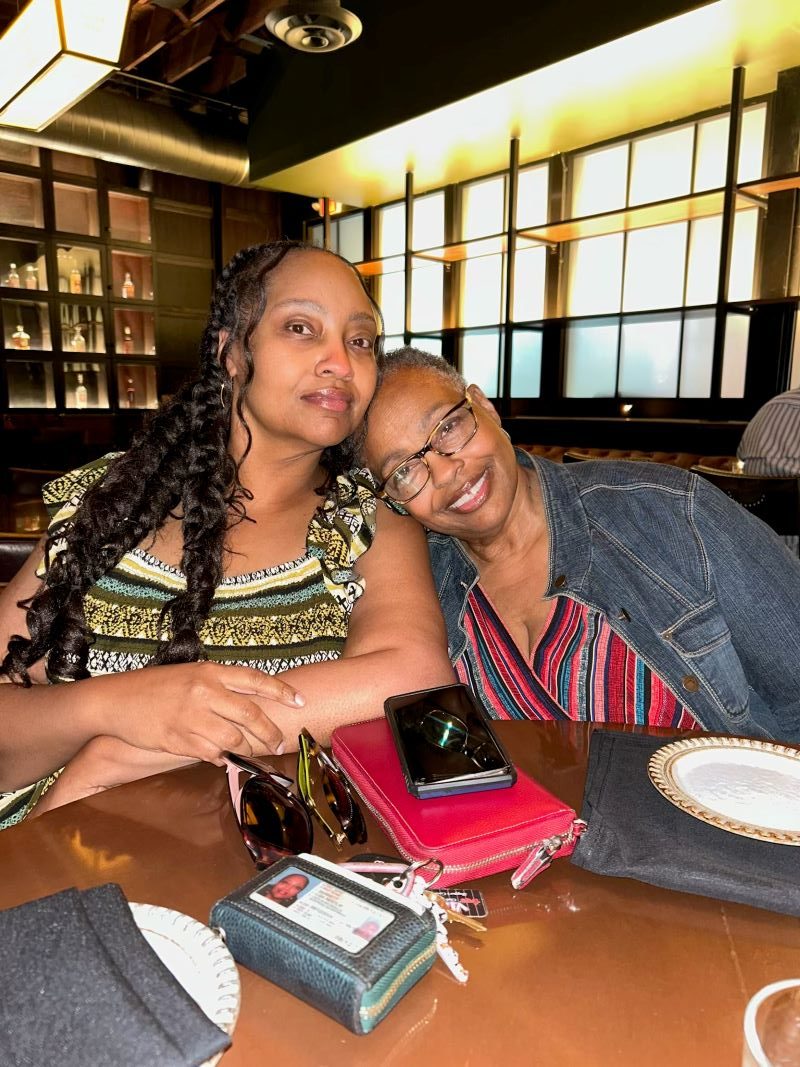 A photo of Nestlie and Gigi sitting at a table at Char Bar, dressed beautifully, enjoying drinks and the warm, moody speakeasy atmosphere.